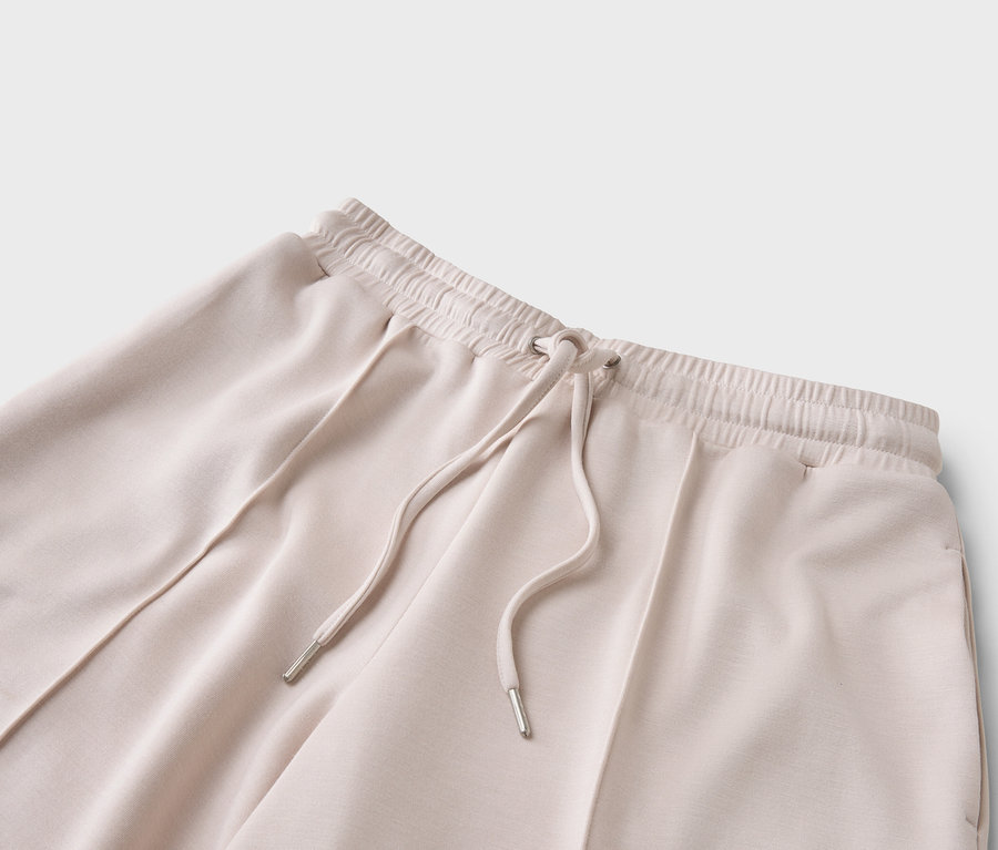 Detail béžových kalhot se stahovací šňůrkou.