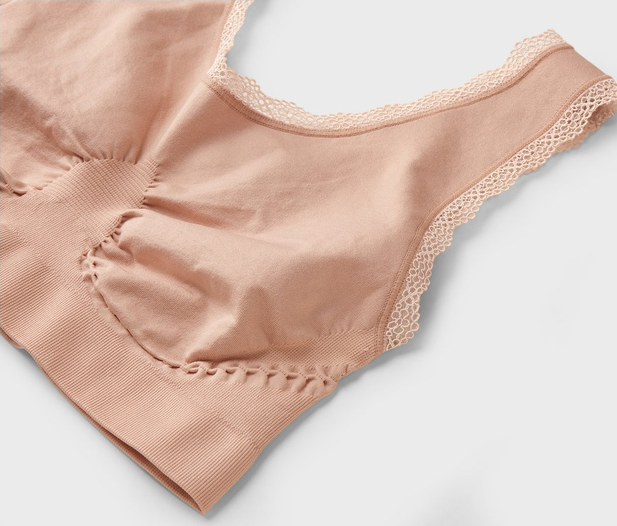 Detailní záběr na tělovou podprsenku s krajkou na výstřihu.