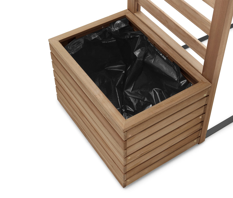 Detailní záběr na dřevěný květináč s černou plastovou vložkou.