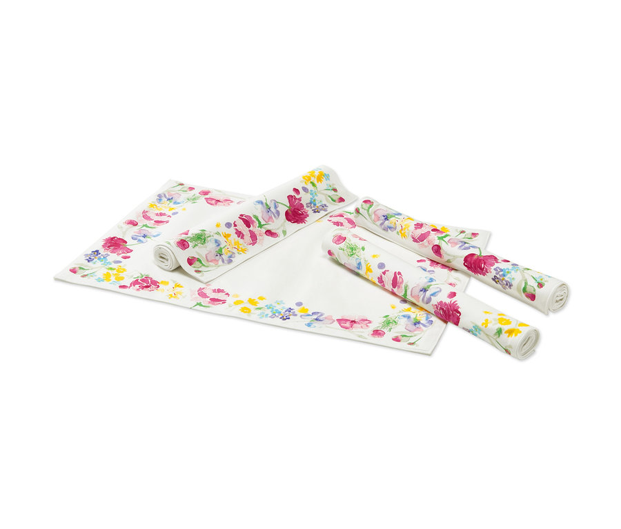Čtyři prostírání s květinovým potiskem, dvě rozložené a dvě srolované.