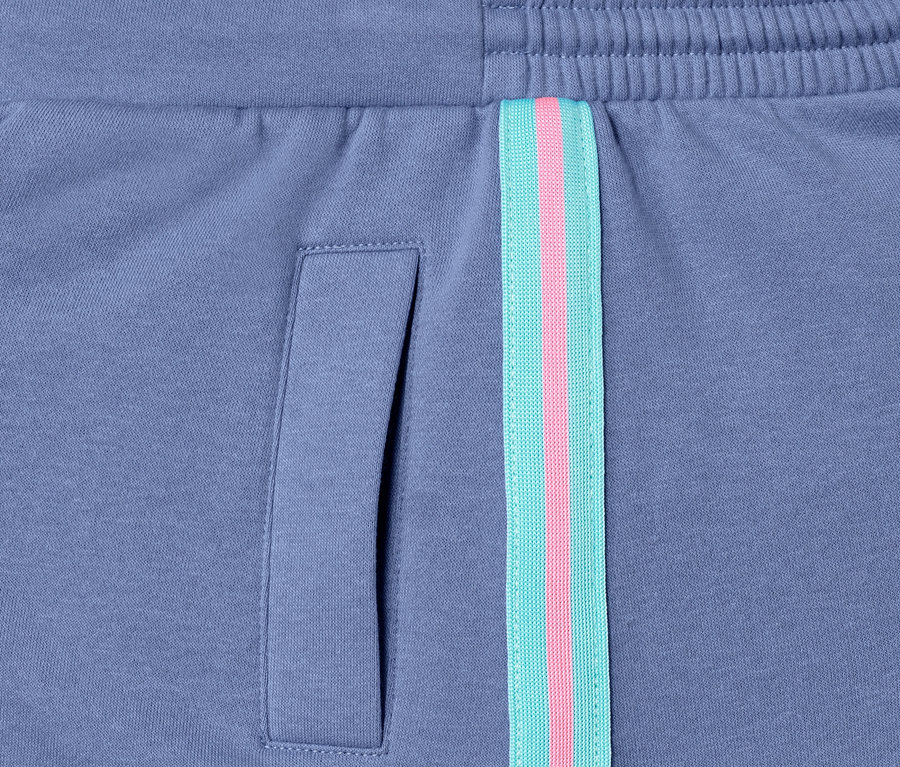 Detail fialové teplákové sukně s kapsou a ozdobným pruhem.