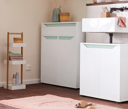 Interiér koupelny s umyvadlovou skříňkou, odkládací skříňkou a vysokou skříňkou. Stojací regál se 3 úložnými přihrádkami a polstrovaná lavice na sezení s úložným prostorem na kolečkách.