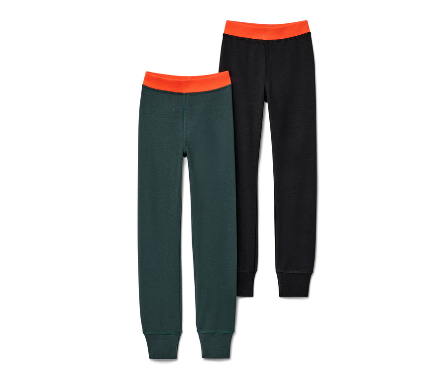 Dvoje dětské zimní legíny: jedny tmavě zelené a jedny černé, oboje s oranžovým pasem.