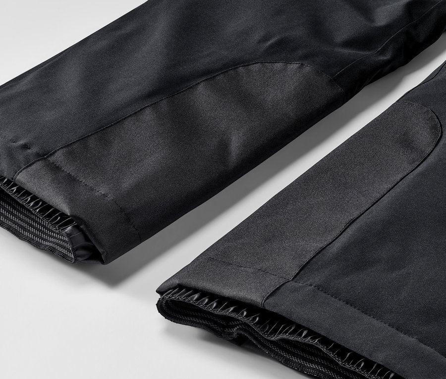 Detailní záběr na černé lyžařské kalhoty.