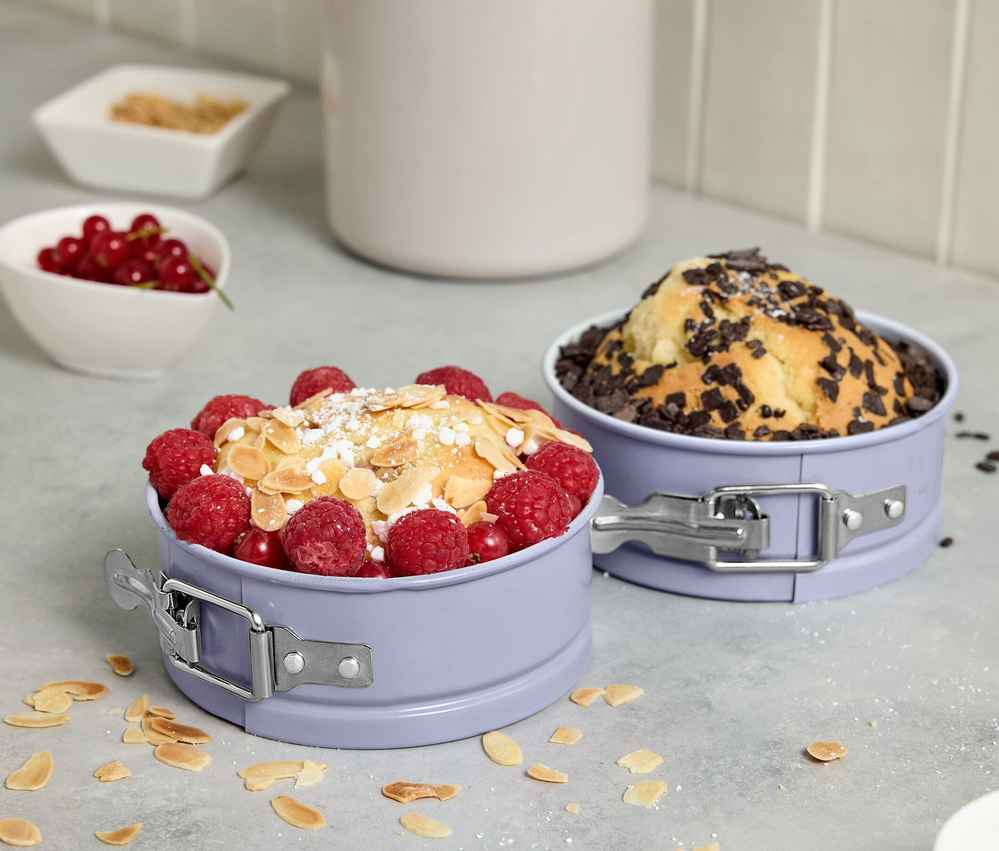 Dva mini dorty ve formách na dort s ovocem a čokoládou.