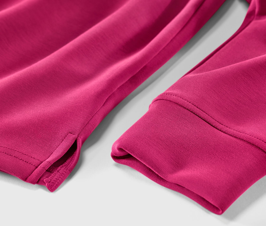 Detail růžové mikiny s kapucí z modalové směsi, ukazující lem rukávu a rozparek.