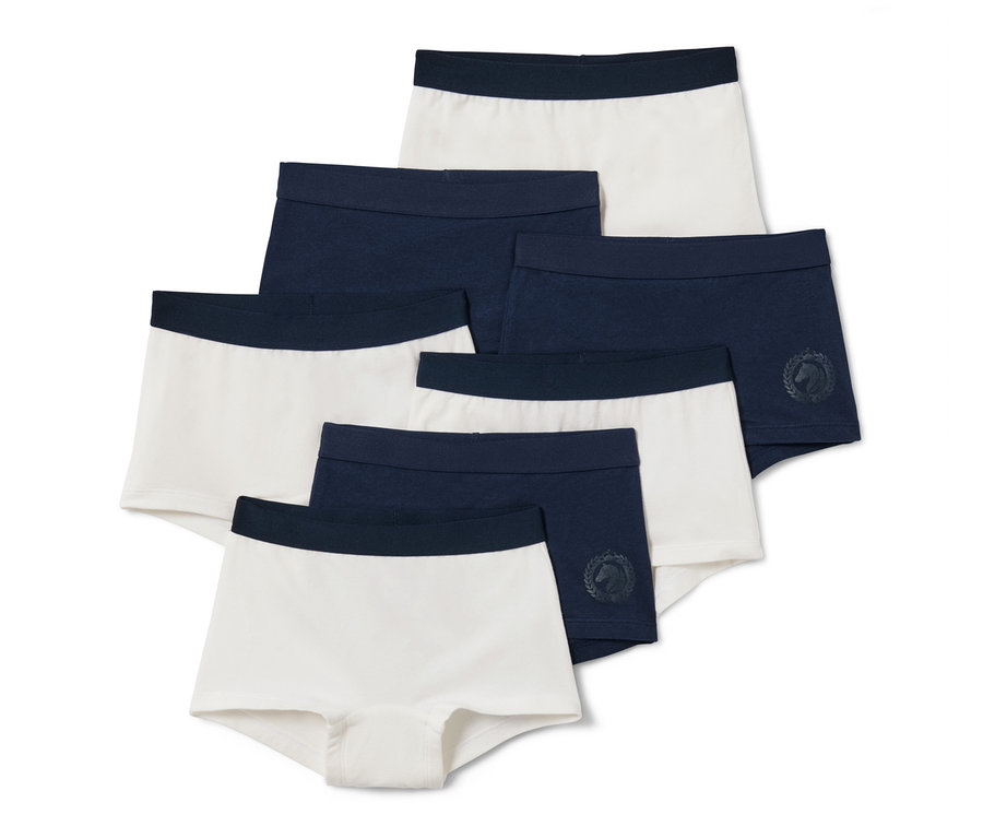 Sedm párů dětských kalhotek.