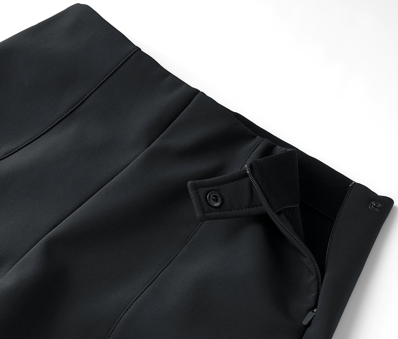 Detail černé sukně se zapínáním na zip a knoflíky.