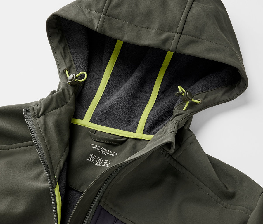 Detail khaki softshellové bundy s kapucí a neonově žlutými detaily.