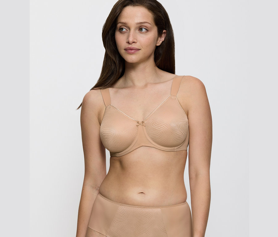 Žena má na sobě zmenšující podprsenku Triumph Essential »Minimizer W X« v tělové barvě.