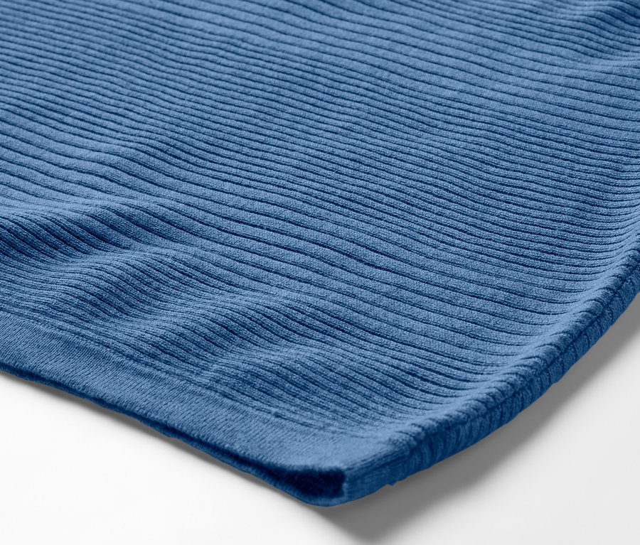 Detail modrého svetru z jemného úpletu.