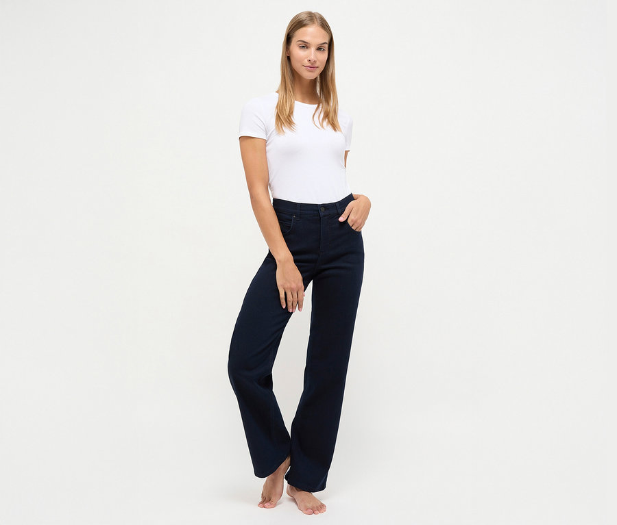 Žena pózuje v tmavě modrých džínách Angels »Lara« straight fit a bílém tričku.