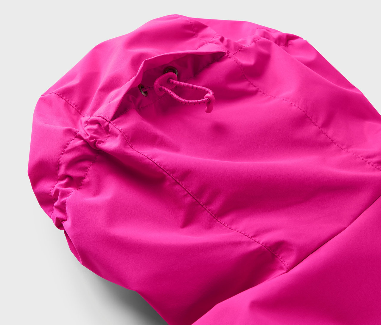 Detail kapuce růžové bundy se stahovací šňůrkou.