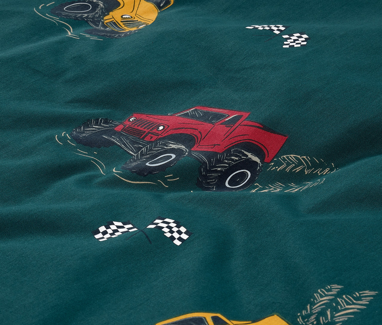 Detailní pohled na dětské renforce povlečení s potiskem aut.