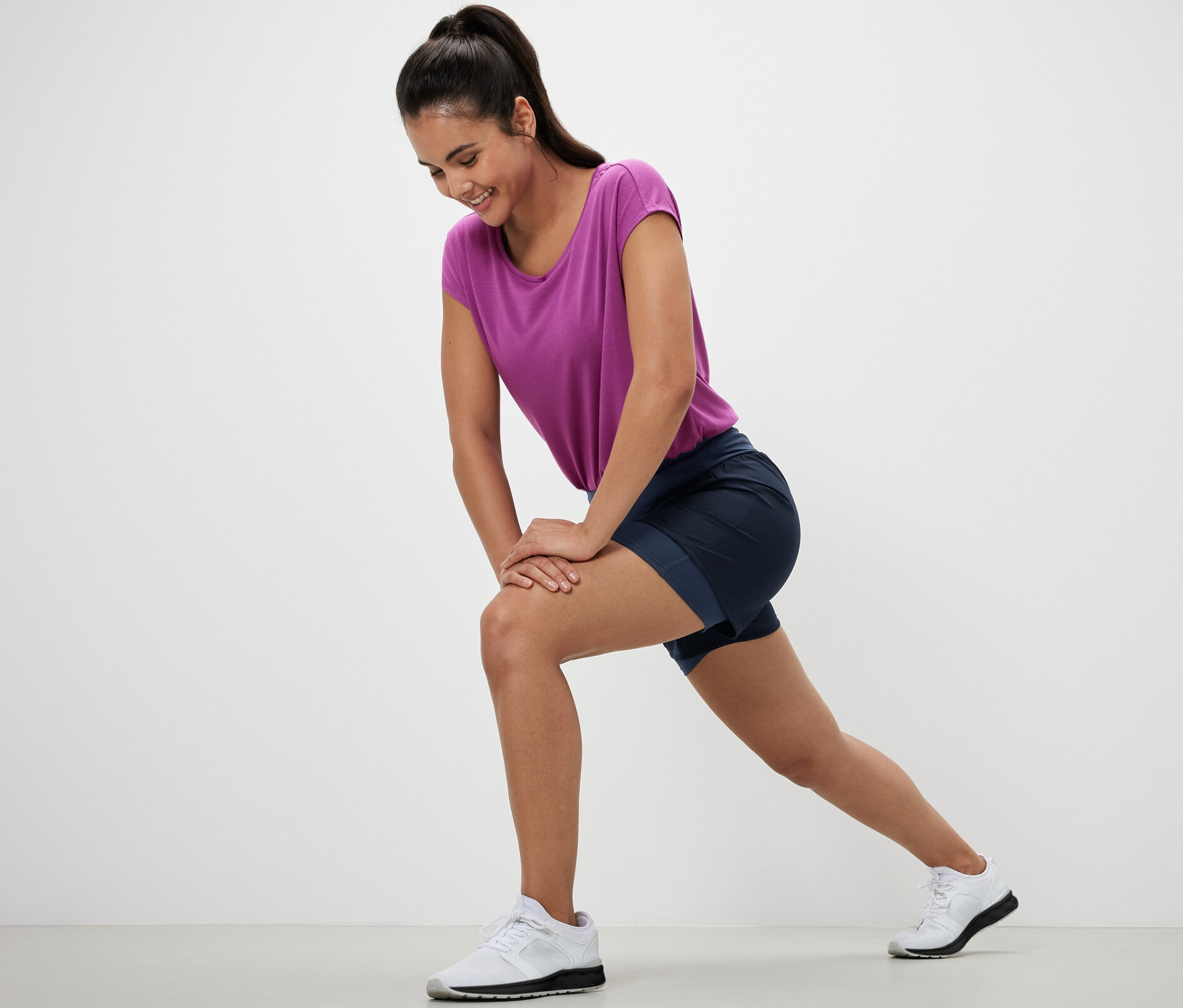 Žena se protahuje v bežeckých šortkách 2 v 1.