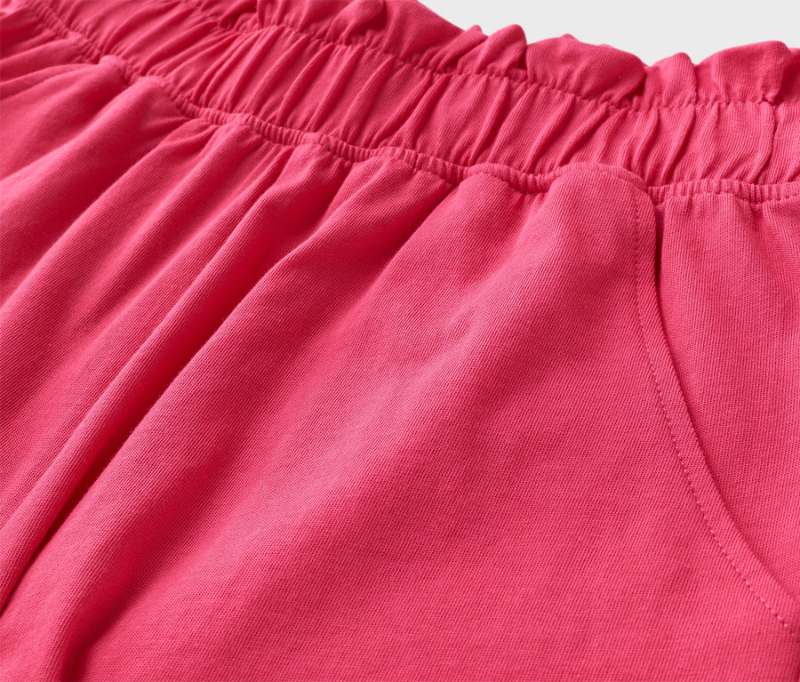 Detail růžových šortek s elastickým pasem a kapsou.
