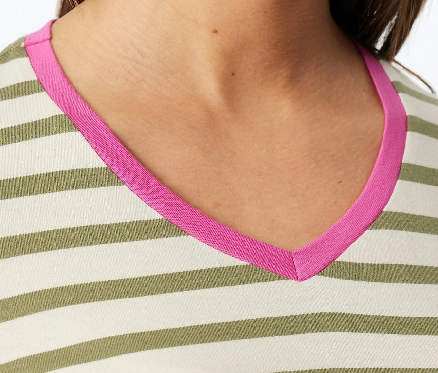 Detailní záběr ženy v pruhovaném topu s růžovým výstřihem do V.