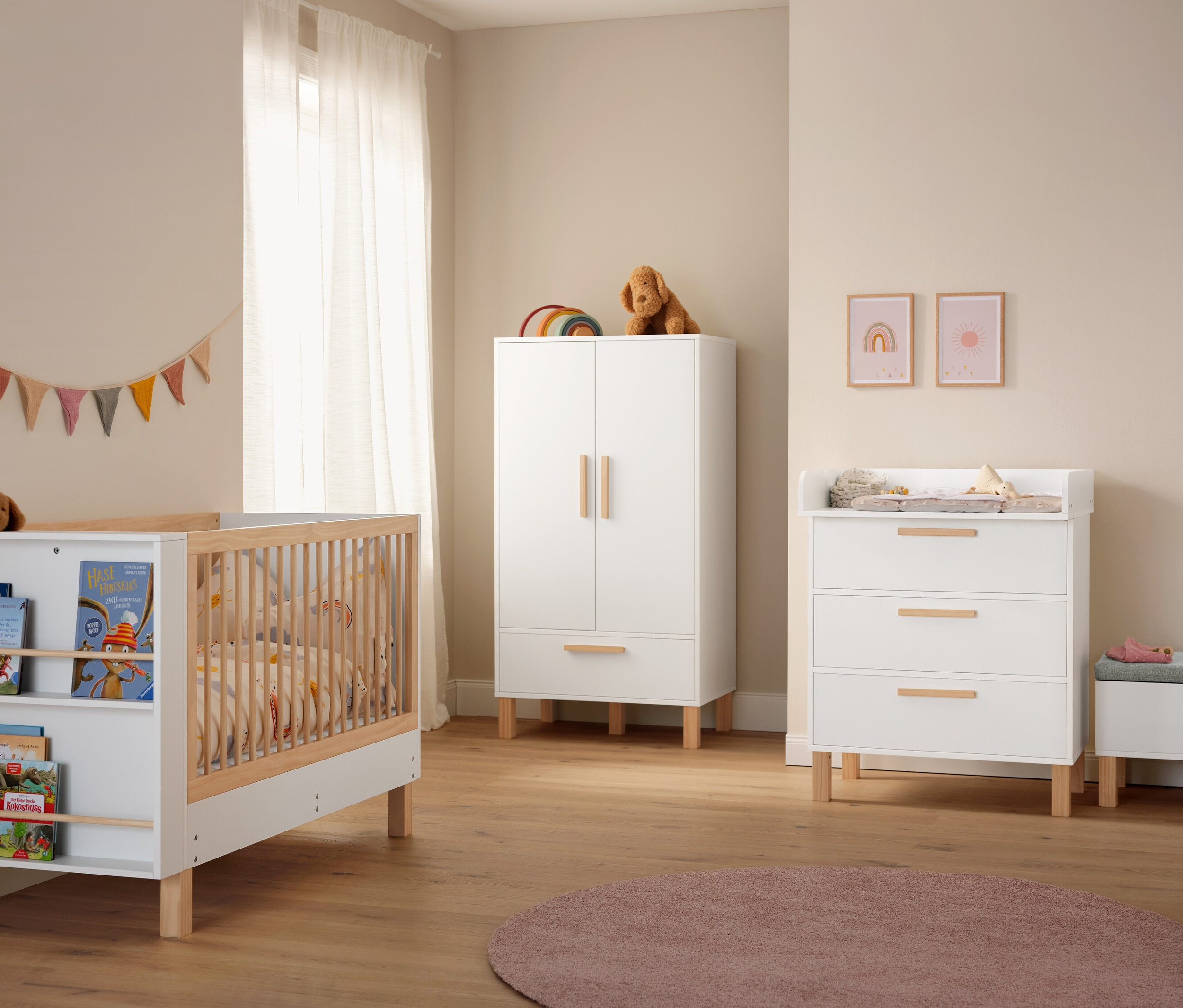 Dětský pokoj s bílou skříní, přebalovacím pultem, postelí s knihami a růžovým kobercem »Charme«, cca 160 cm.