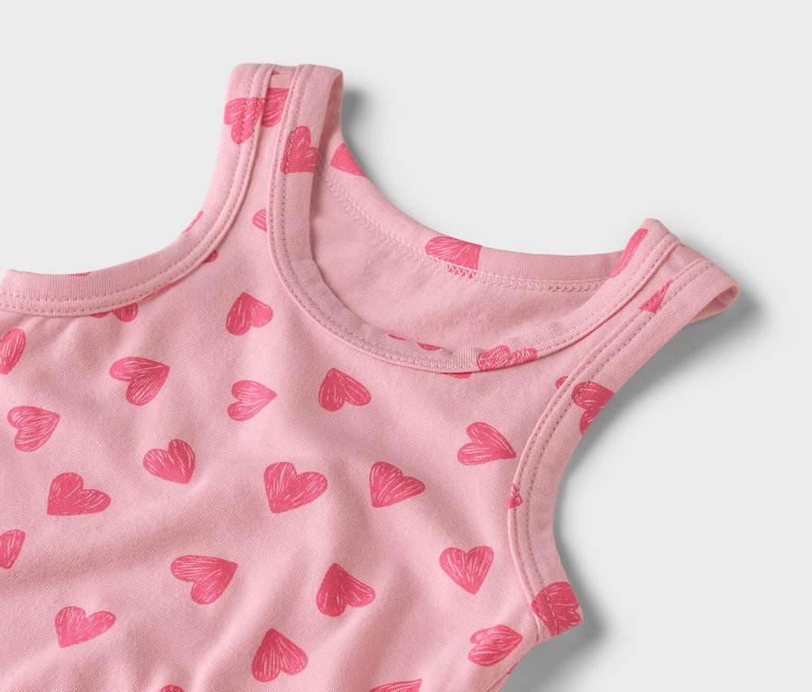 Detail růžového tílka se vzorem červených srdíček.