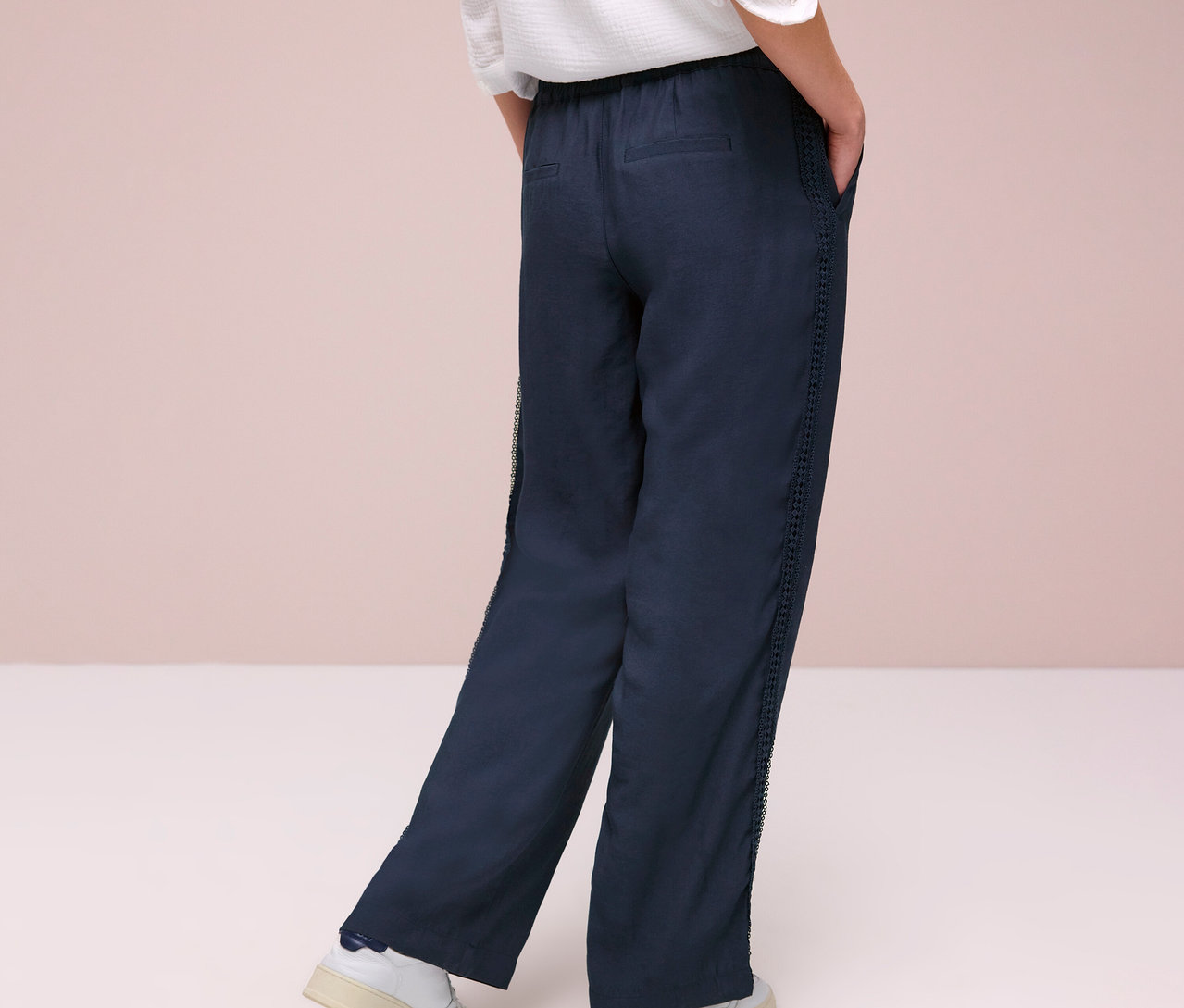 Osoba zezadu v kalhotách Street One »Emee« a bílých teniskách.