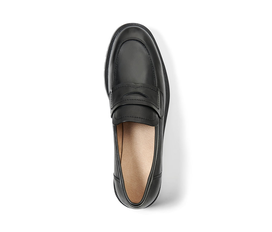 Černý kožený mokasín na bílém pozadí.