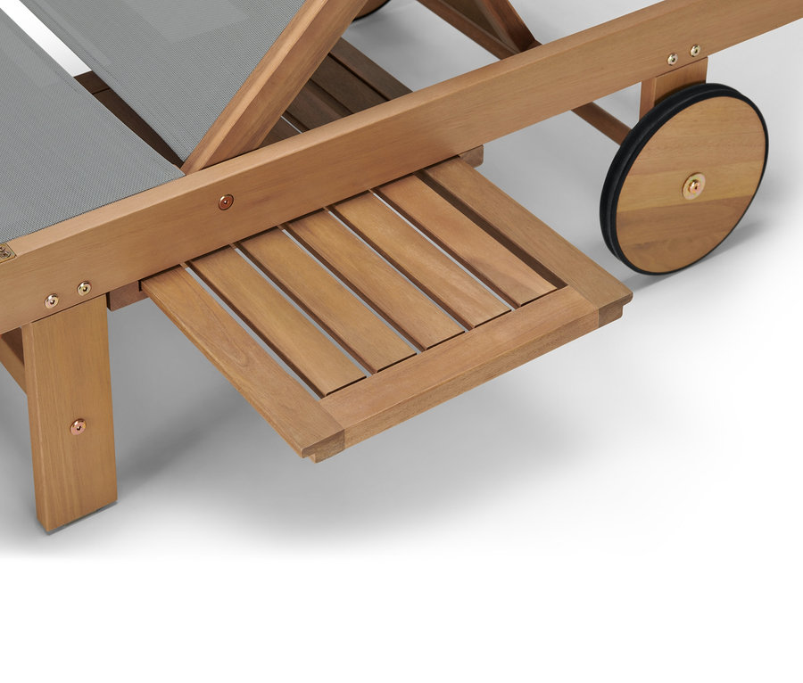 Detail dřevěného lehátka Lenja s výsuvným odkládacím stolkem.