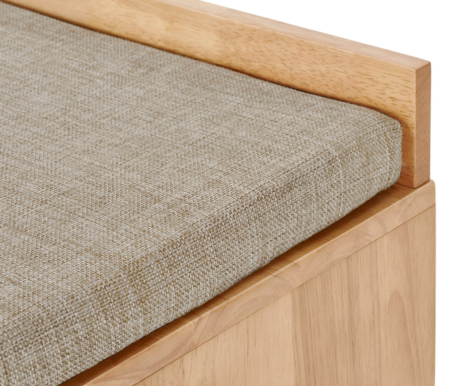 Detail lavice s úložným prostorem a béžovým látkovým sedákem.