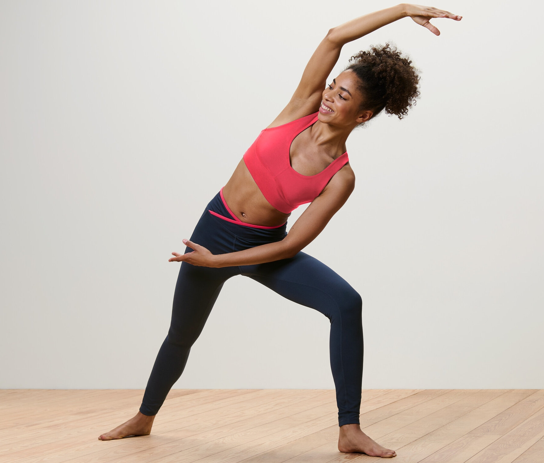 Žena se natahuje ve sportovních legínách.