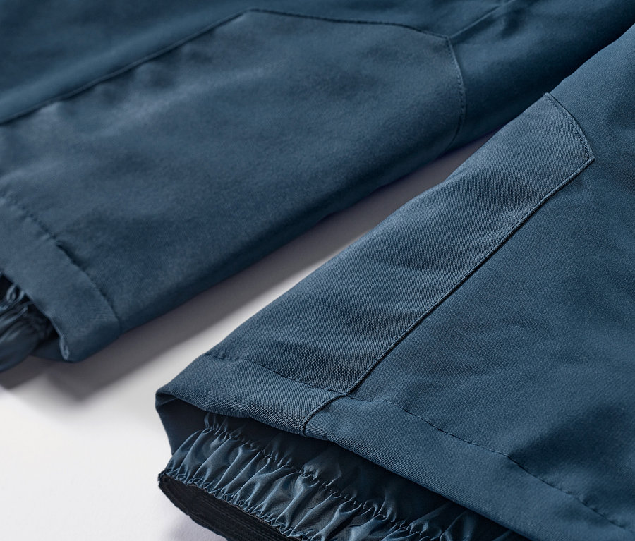 Detail lyžařských a snowboardových kalhot v námořnické modré barvě.