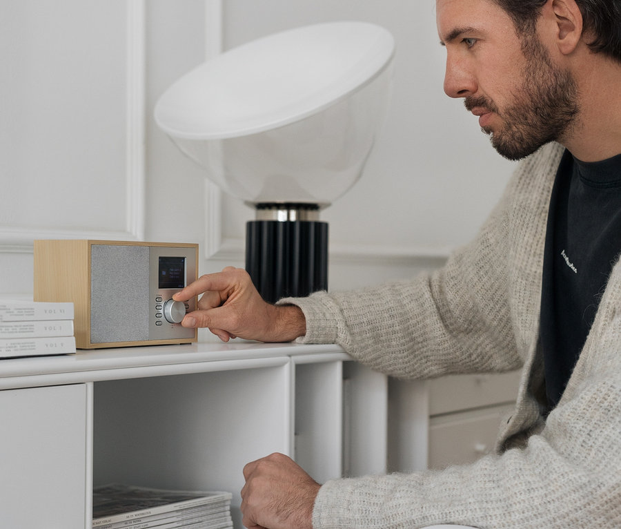 Muž ladí digitální rádio DAB+/FM s Bluetooth.