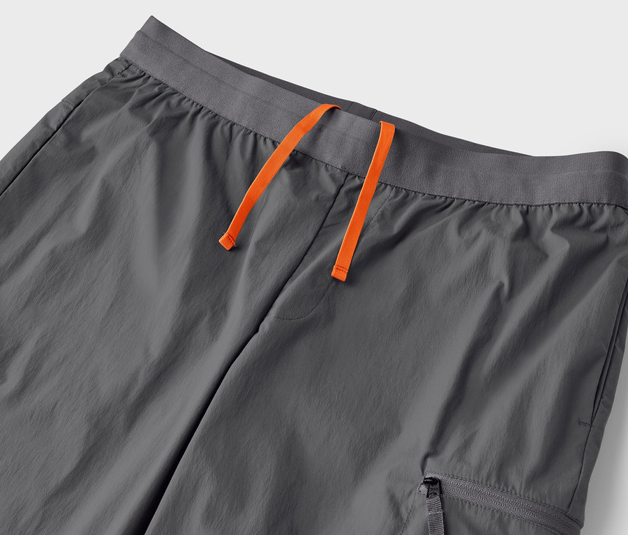 Detail šedých lehkých funkčních kalhot se šňůrkou v pase.