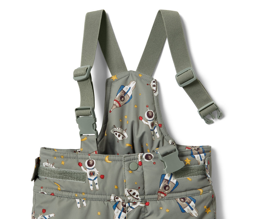 Detail dětské zimní kombinézy s potiskem kosmonautů, raket a hvězd.