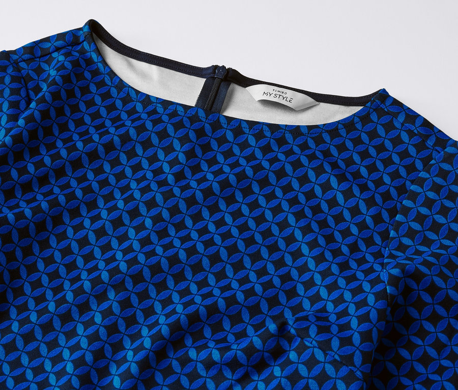 Detail žerzejových šatů s potiskem.