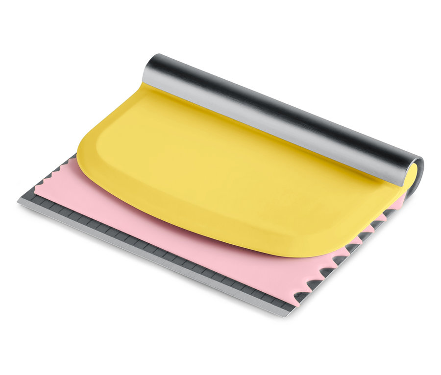 Žlutá stěrka s růžovou vroubkovanou hranou a stříbrnou rukojetí.