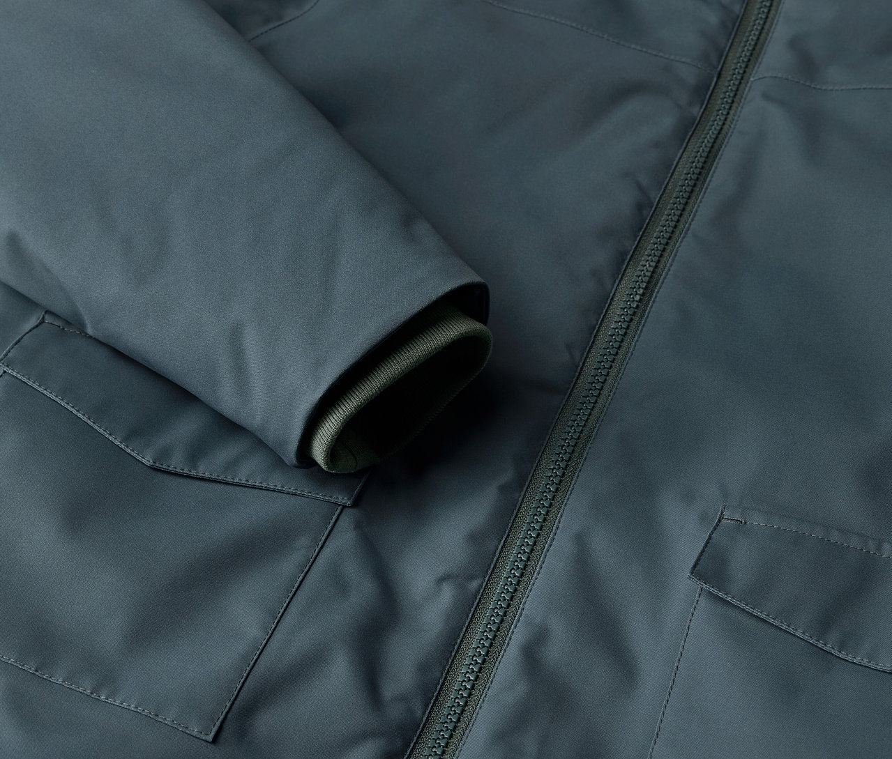 Detail dětské zimní parky s kapsou a zipem.