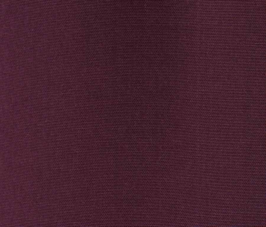 Detailní záběr na texturu látky v tmavě fialovém odstínu.