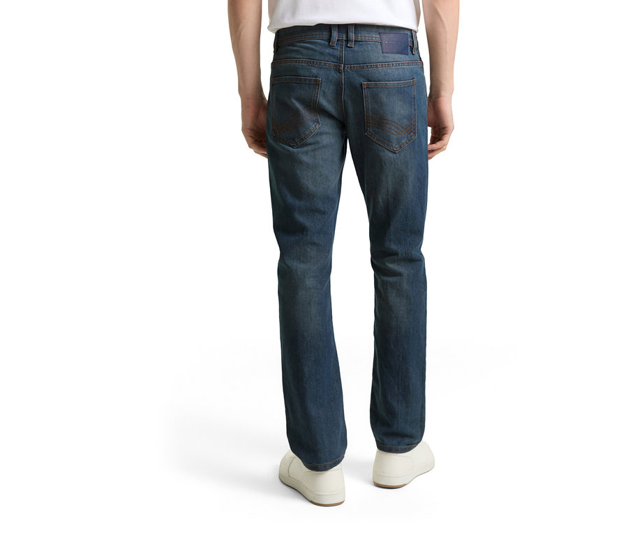 Pohled zezadu na osobu v džínách Tom Tailor TT MARVIN STRAIGHT se strečovým materiálem, Mid Stone Blue Grey Denim a bílých botách.