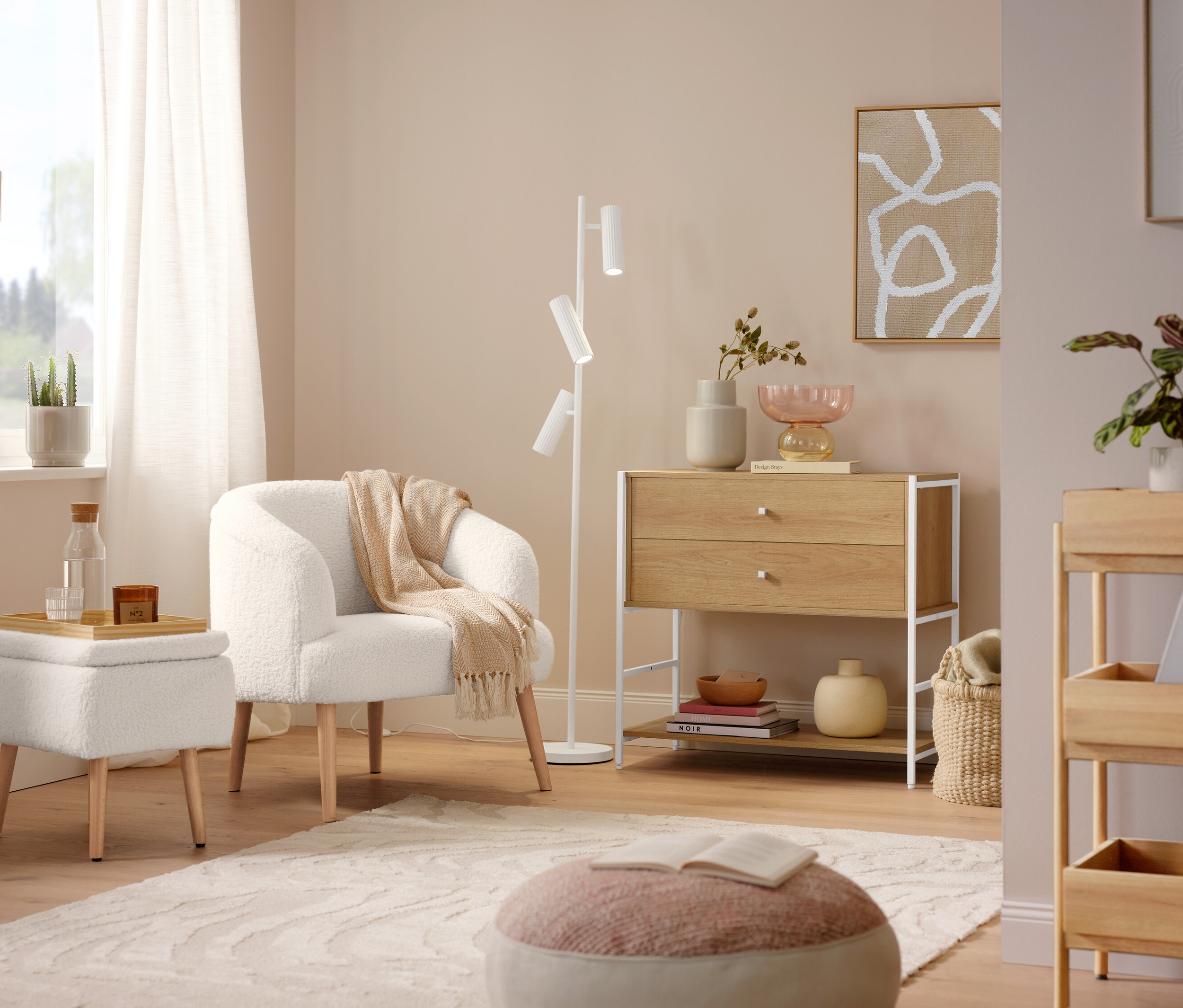 Křeslo z buklé s dřevěnými nohami stojí vedle lampy Trio »Soka«. Na podlaze leží šedý koberec »Cosmo «Waves.