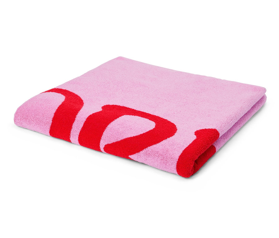 Složený světle růžový ručník s červeným potiskem písmen leží na bílém pozadí.