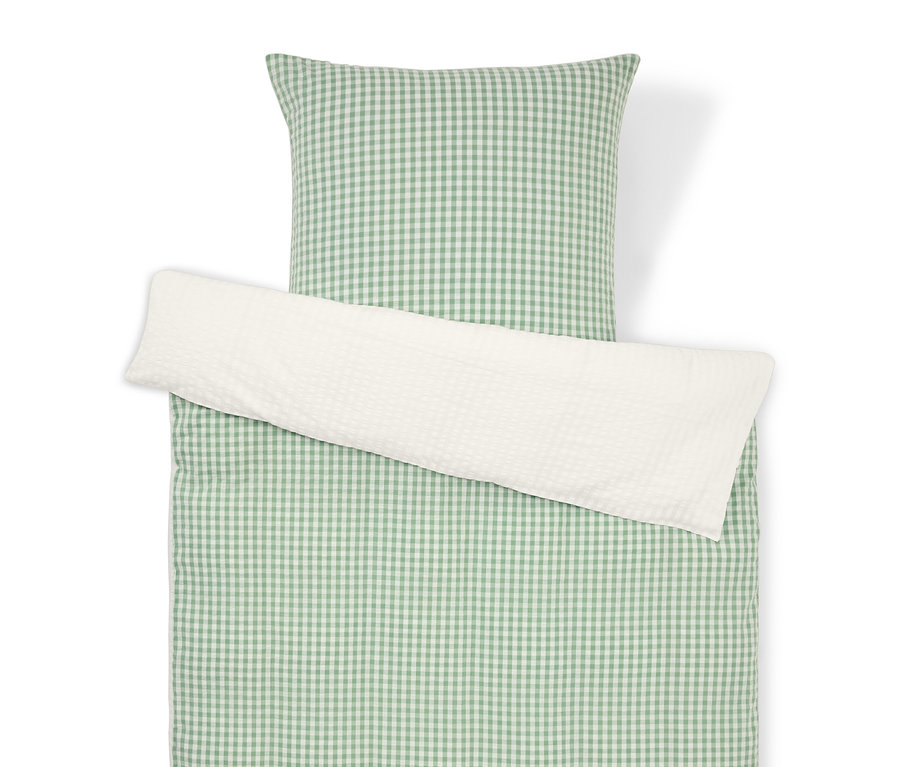 Pohled shora na soupravu ložního prádla se zeleno-bílým kostkovaným vzorem a bílým povlakem na polštář.