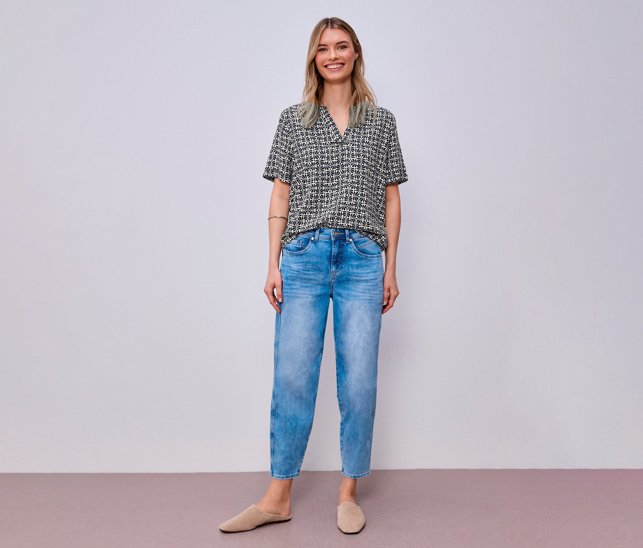 Usmívající se žena v džínách a tkané halence Street One se vzorem.
