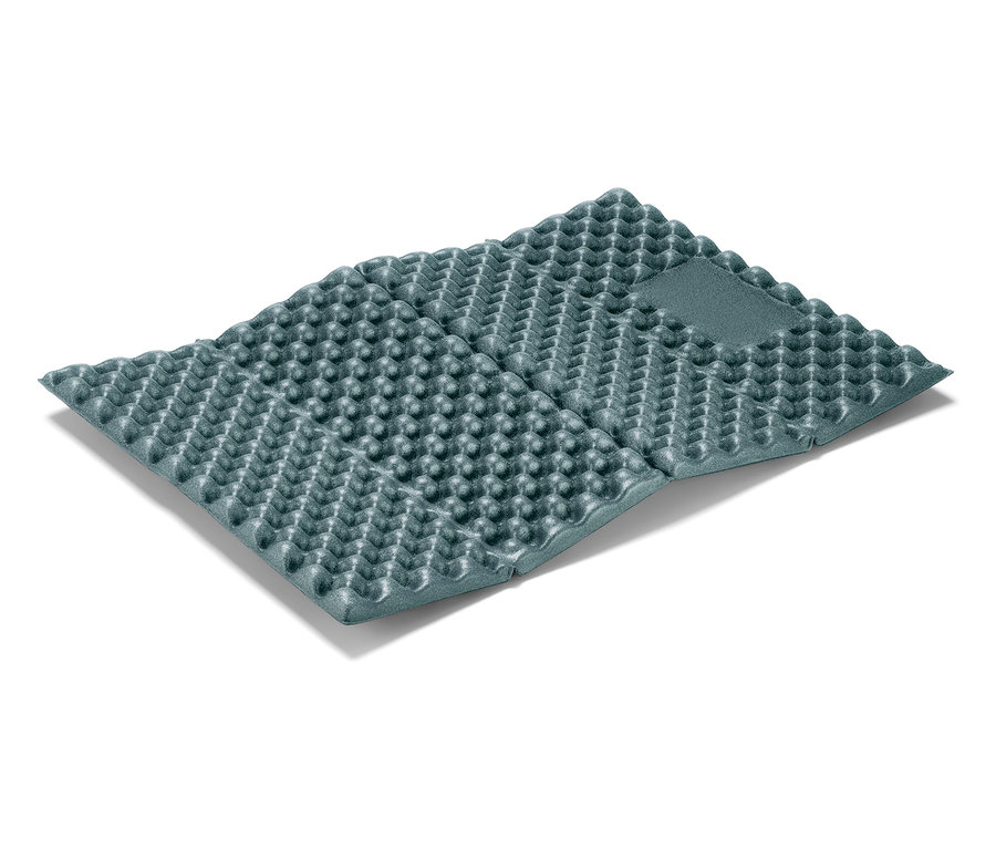 Složená šedá karimatka leží na bílém pozadí.