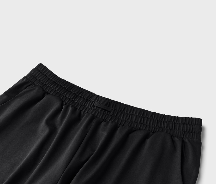 Detailní pohled na černé kalhoty s elastickým pasem.