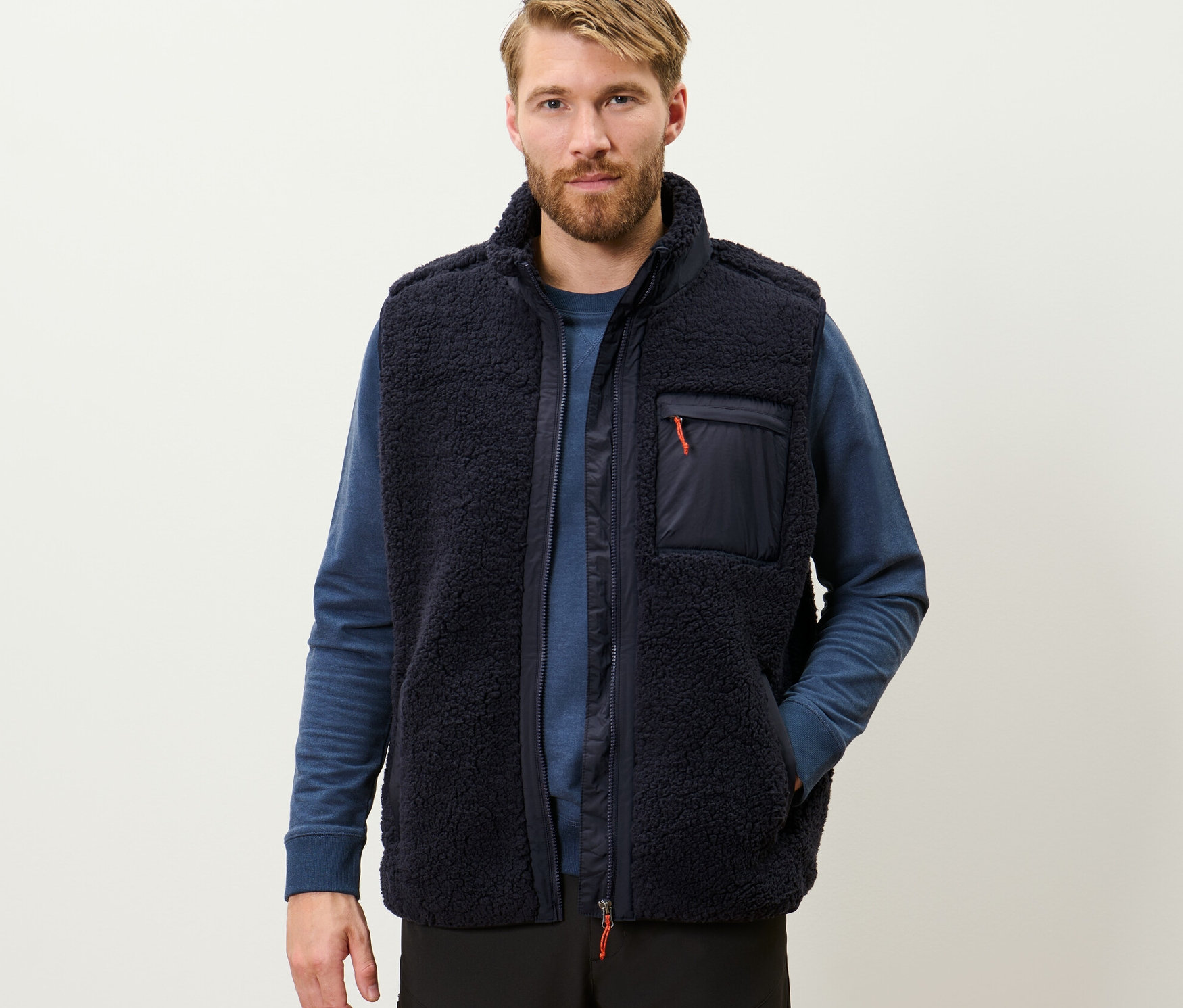 Muž má na sobě plyšovou vestu.