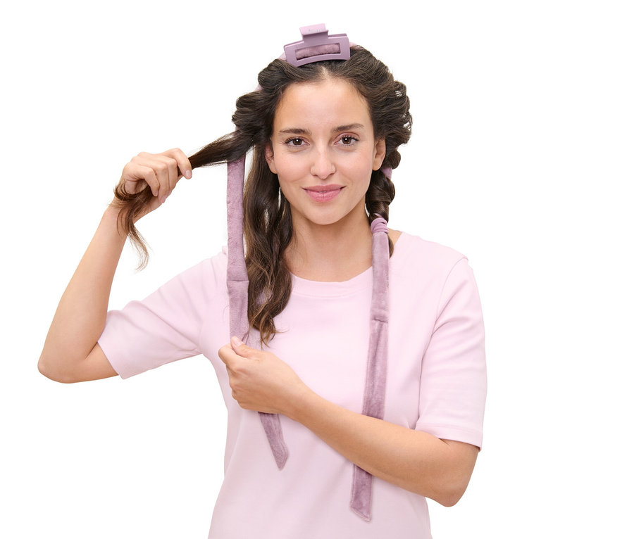 Žena si natáčí vlasy pomocí sady pro natáčení vlasů bez použití tepla.