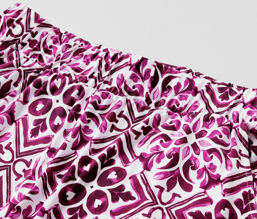 Detail potištěných kalhot se širokými nohavicemi v bobulové barvě.