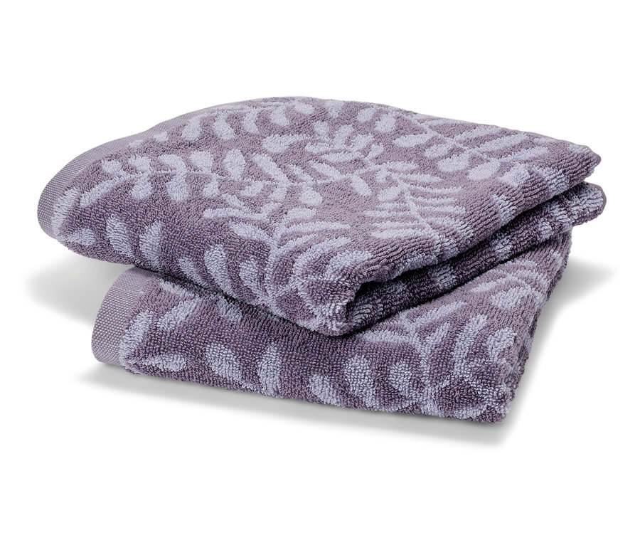 Dva froté ručníky fialové barvy složené na sobě. Na ručnících je jemný vzor listů.