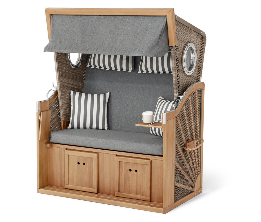 Proutěný plážový koš s šedými polštáři a pruhovanými akcenty.