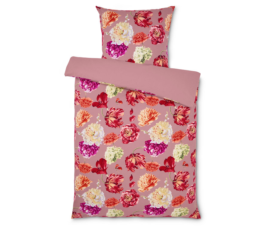 Povlečení s květinovým vzorem na růžovém pozadí.
