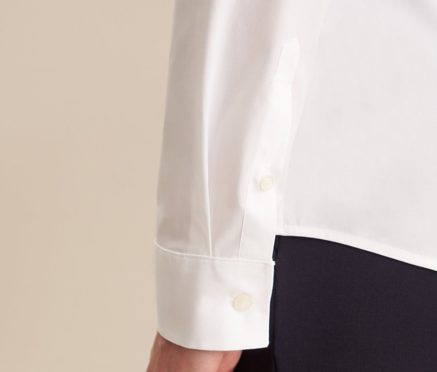 Detail bílé halenky slim fit Seidensticker s dlouhým rukávem a manžetou na knoflíček.